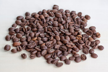 Roasted coffee beans on a wooden background. Coffee and light wood background. Seeds.