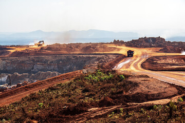 Open pit mine in Africa, with huge crane and trucks to bring ore to a processing plant 