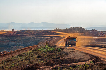 Open pit mine in Africa, with huge crane and trucks ro bring ore to a processing plant 