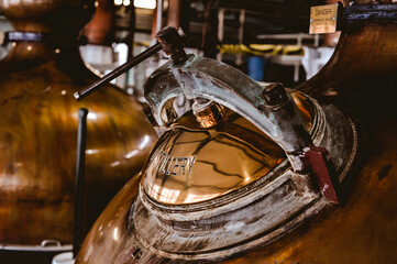 Detail shot of a copper stills main hatch. Shallow depth of field. Scotch distillery in Scotland.  - obrazy, fototapety, plakaty