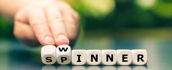 Hand turns dice and changes the word spinner to winner.