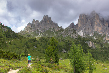 Fototapeta na wymiar Incredible nature landscape in Dolomites Alps. Spring green blooming meadow. Panorama of Dolomites,Italy. Woman hiking in mountains.Active lifestyle.Girl backpacker,adventure vacations.Summer holiday
