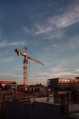 Construction crane on construction site during sunset 