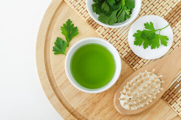 Parsley juice, cotton pad and wooden hair brush. Ingredients for preparing homemade eye mask or skin toner. Natural beauty treatment recipe, zero waste concept. Top view, copy space