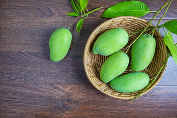 .Fresh green mango fruit in a wooden basket