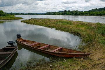 Obraz premium old fishing boats in the calm waters of the Vistula river at cloudy day