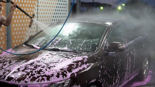 Washing off the foam from the car. High pressure car wash