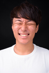 Obraz premium Young handsome Asian man against black background