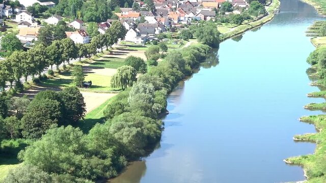 Zoom in on the river Weser near Bad Karlshafen, Germany, with residential houses and green meadows, aerial view
