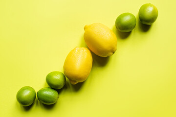 top view of ripe lemons and limes on colorful background