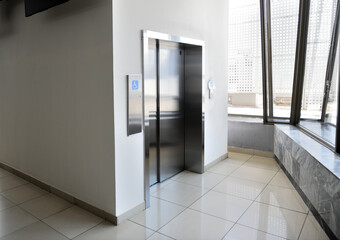 disabled signage, Modern steel elevator cabins in a business lobby or Hotel, Store, interior, office,perspective wide angle.