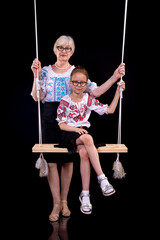 Grandmother and granddaughter in embroidered shirts on a black background. National clothes of Ukrainians. Ukraine's Independence Day