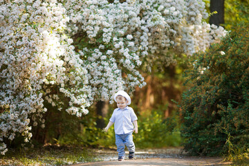 Naklejka premium Child running in an apple orchard in spring
