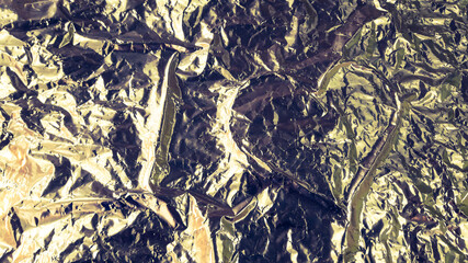 Abstract background. Heart shape in the middle of a crumpled aluminum foil.