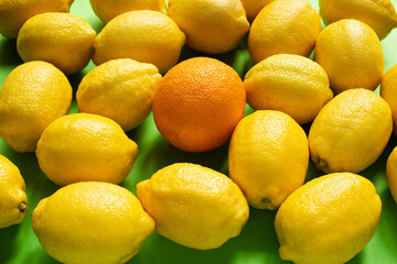 fresh ripe yellow lemons and orange on green background