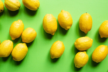 top view of ripe yellow lemons scattered on green background