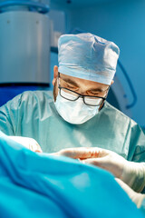 Surgeon in glasses providing surgical operation. Medical concept.