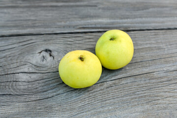 Closeup on fresh and recently picked yellow apples placed on wooden board