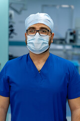 Fototapeta na wymiar Portrait of the professional surgeon. Doctor wearing mask. Medicinal standing near professional equipment.