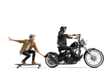 Obraz na płótnie Canvas Elderly biker riding a chopper and pulling a guy on a skateboard