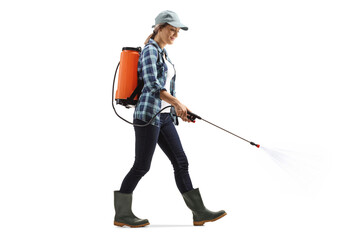 Full length shot of a female farmer walking and spraying a fertilizer