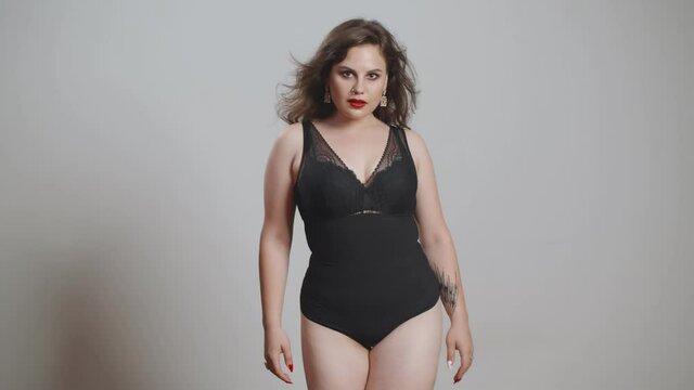 Attractive plus size young lady in bodysuit with bright makeup