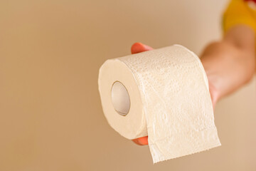 Man's hand holding and giving toilet paper roll.