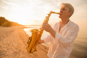 The musician plays the saxophone on a Golden sunset 