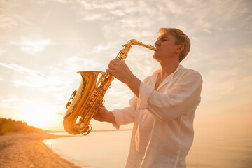 The musician plays the saxophone on a Golden sunset 
