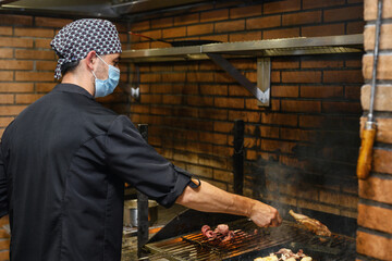 Chef grilling steaks in commercial kitchen. High quality photo