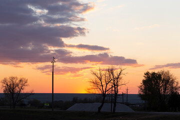 Landscape at sunset. Tragic gloomy sky. The village in the Budjak steppe. The terrain in southern Europe. Panorama. Crimson twilight.