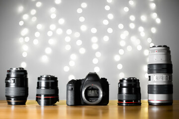 Open mount and sensor digital camera with professional set of premium lenses on wooden table on...