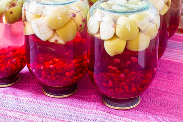 Homemade canned fruit compote for the winter. Compot from apples and red currant. Inverted jars