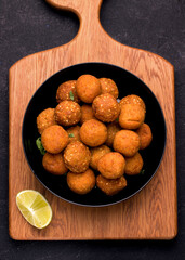 A Middle Eastern dish of falafel. Fried balls on a wooden board. vertical photo