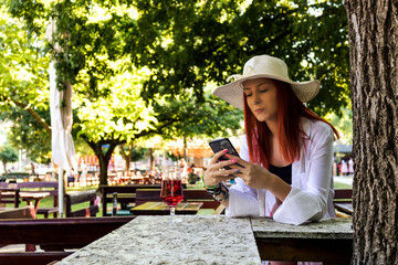 Beautiful woman texting on smart phone in summer day.
