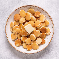 Trendy breakfast with mini pancakes and butter.