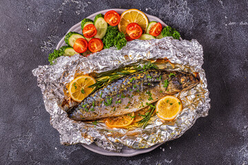Mackerel baked in foil with vegetables on a dish