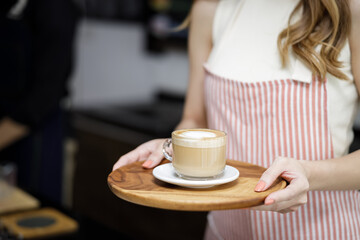 Close up women holding cup of coffee latte at coffee shop