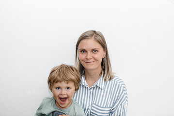 son and young mother hug and kiss. the child congratulated his mother on her birthday and presented bouquet 