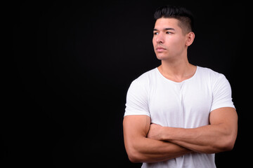 Young handsome multi ethnic man against black background