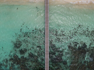 Wood dock above a reef on a paradise beach in Raja Ampat, Papua, Indonesia