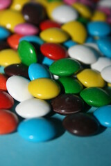 multicolored delicious candies with chocolate on a blue background