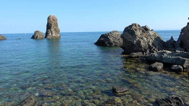 View of the Faraglioni of Acitrezza. Rocks of the Cyclops, typical lava stacks. Sicily, Italy. Footage 4k