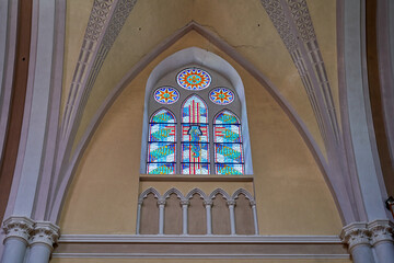The stained glass window in the church near the ceiling