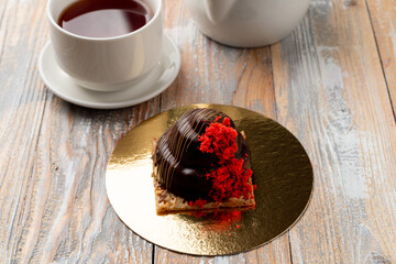 One glazed truffle candy on a golden plate with strawberry crumbs as a decoration