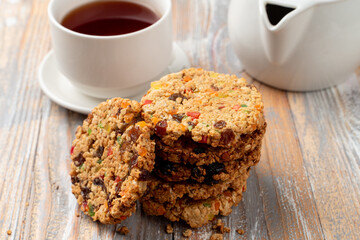 A stack of whole grain golden crunchy cookies with jest and candied fruits