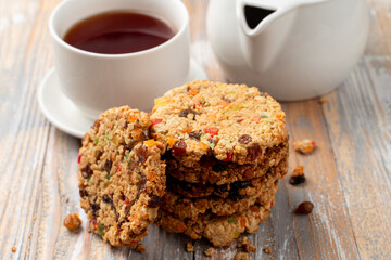 A stack of whole grain golden crunchy cookies with jest and candied fruits