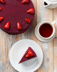 Top view of strawberry cake served with a cup of tea, strawberry birthday cake, directly above view on wooden table