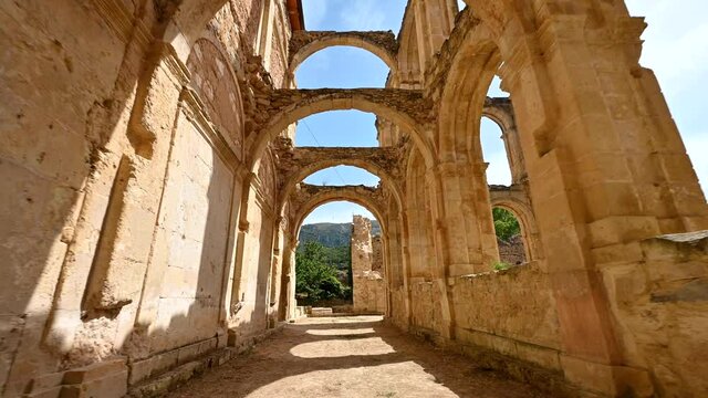 POV walking inside cloister ruins of an ancient abandoned Monastery Santa Maria De Rioseco, in Burgos, Spain. High quality 4k footage