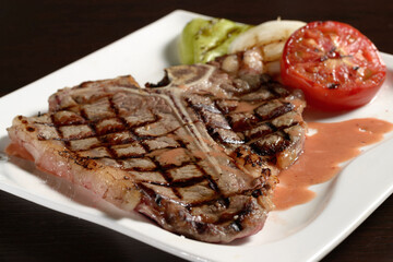 Grilled marbled beef T-bone steak close-up with grilled vegetables. Photos for restaurant and cafe menus